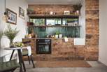 The far wall is home to the kitchen, with everything you need hidden behind upcycled wood cupboards and a polished concrete worktop