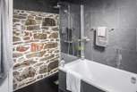 The gorgeous bathroom with exposed stone wall is just a delight