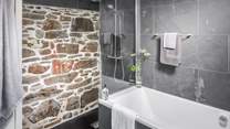 The gorgeous bathroom with exposed stone wall is just a delight