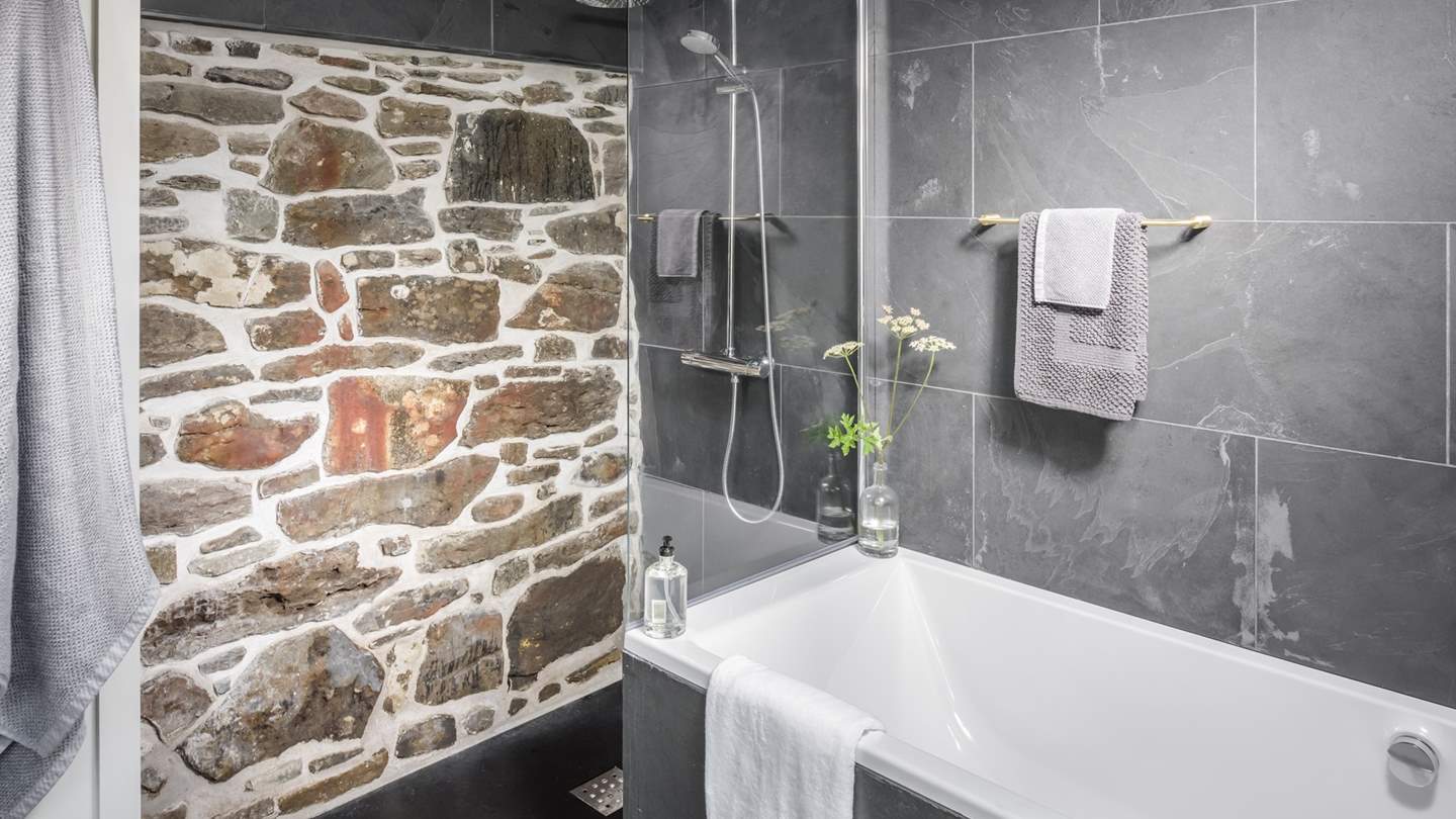 The gorgeous bathroom with exposed stone wall is just a delight
