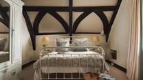 The second bedroom with dark beamed ceilings promises a soothing nights' rest