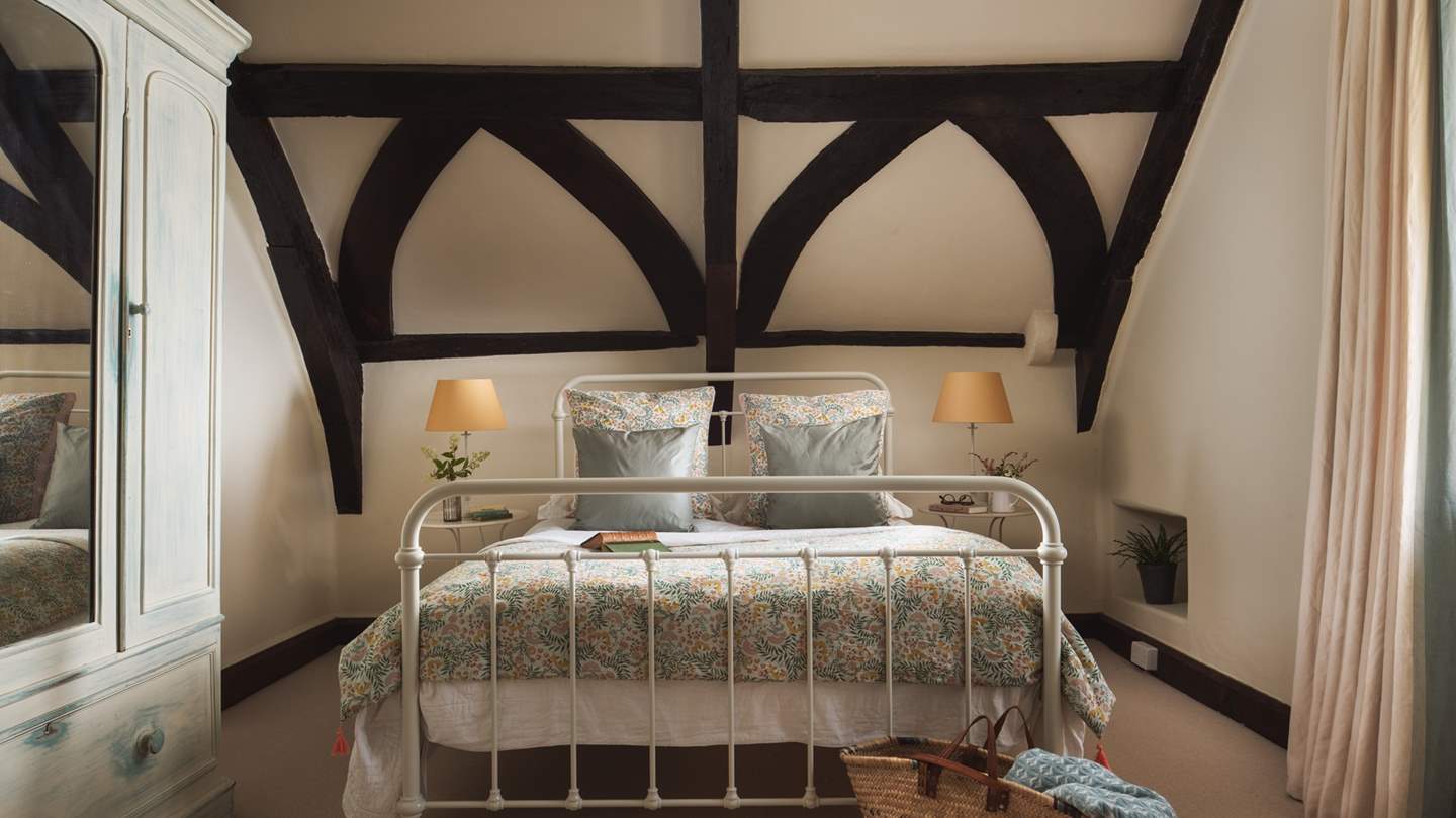 The second bedroom with dark beamed ceilings promises a soothing nights' rest