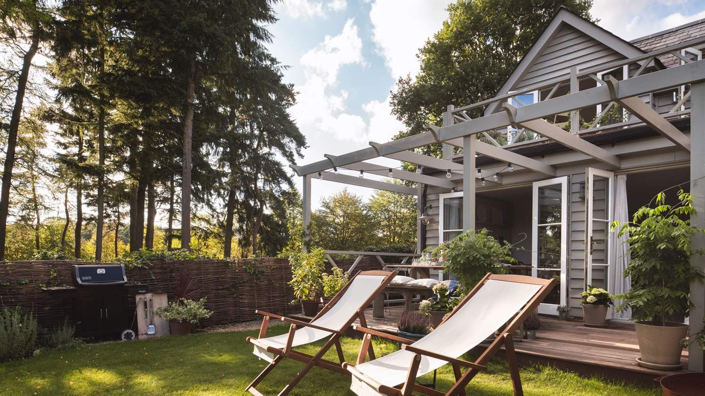 There's a large lawned area with raised beds overflowing with flowers and vegetables