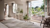 The master en suite bedroom is on the first floor has uninterrupted, south facing views over the Surrey Hills from the expansive deck