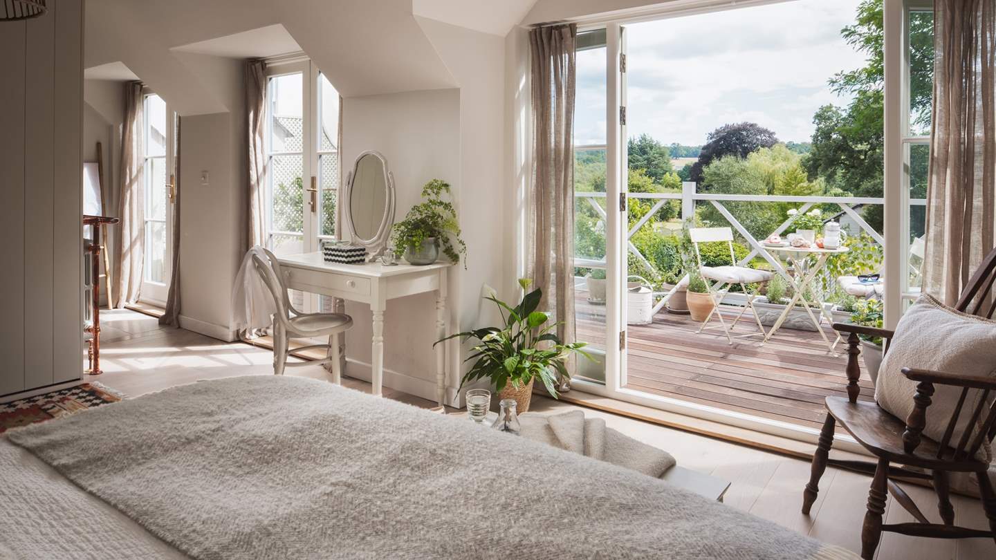 The master en suite bedroom is on the first floor has uninterrupted, south facing views over the Surrey Hills from the expansive deck