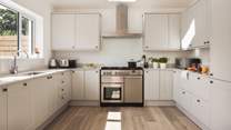 The fully equipped kitchen is positioned at one end of the open-plan space and boasts a Rangemaster range cooker