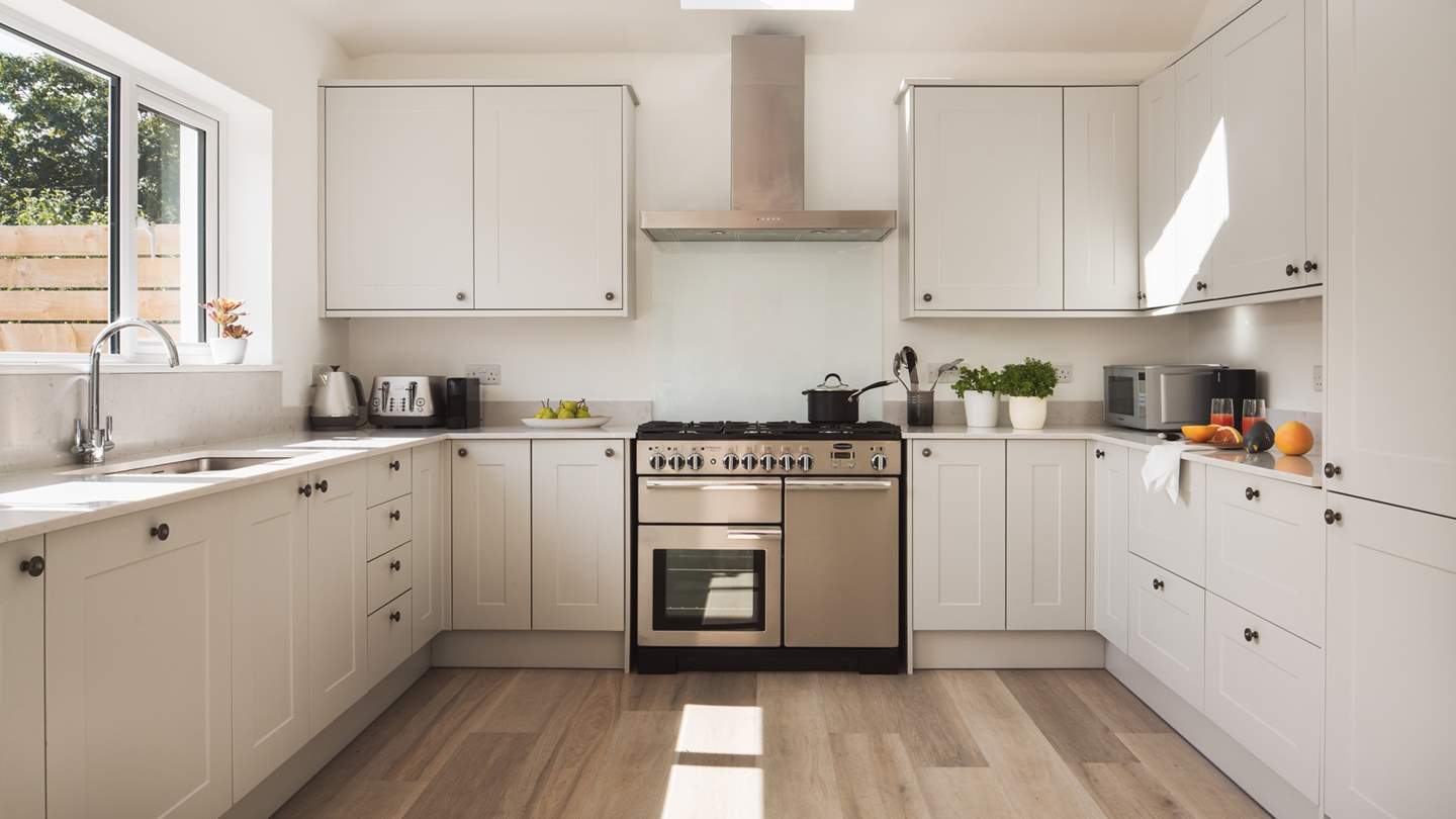 The fully equipped kitchen is positioned at one end of the open-plan space and boasts a Rangemaster range cooker
