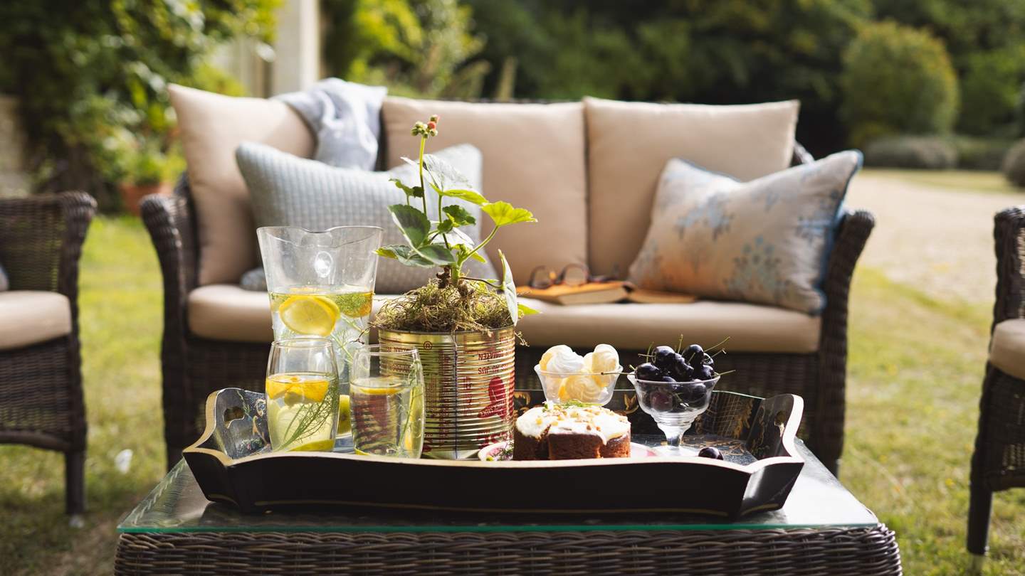 Close to the property are multiple sets of rattan furniture and a table and chairs for alfresco dining