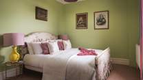 The green bedroom has an oh-so-romantic king-sized bed with floral bed head, original fireplace and built in wardrobe