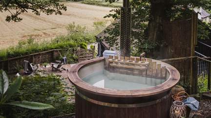 On the garden's upper level and nestled beneath a leafy canopy, the wood-fired hot tub beckons for heavenly dips in the most peaceful setting