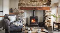 The flickering wood burner is the heart of the pretty sitting room