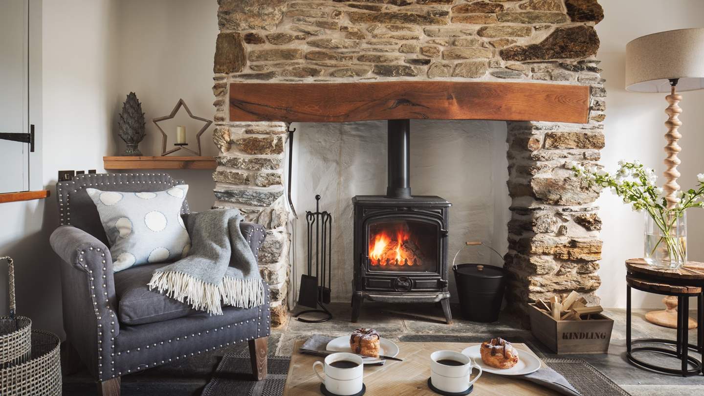 The flickering wood burner is the heart of the pretty sitting room