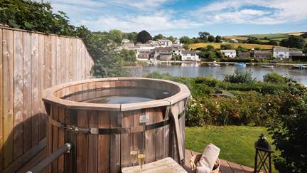 Enjoy the riverside views from the sumptuous wood-fired hot tub 