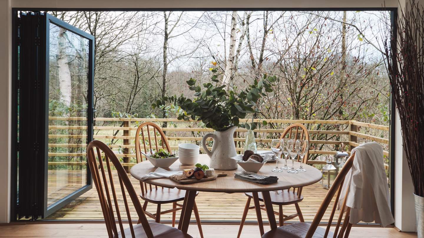 The Ercol quaker-style wooden dining table and chairs is situated to make the most of the views