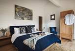 The master bedroom boasts a super king bed, wardrobe, blue velvet occasional chair and easy access to the hot tub from the front