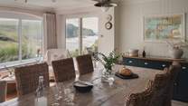 A large dining table sits up to ten guests for mealtimes accompanied by heavenly coastal panoramas
