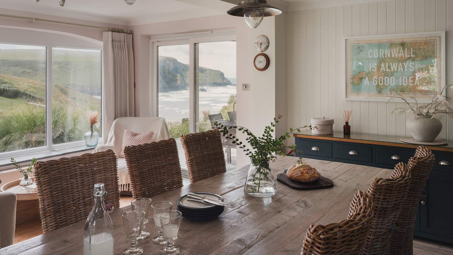 A large dining table sits up to ten guests for mealtimes accompanied by heavenly coastal panoramas