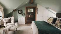 The master en suite bed lies up in the eaves of the house, with magnificent, vaulted windows overlooking the sea