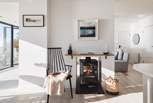 The cosy wood burner, accessible from both the sitting and dining areas, offer cosy heat during cooler months