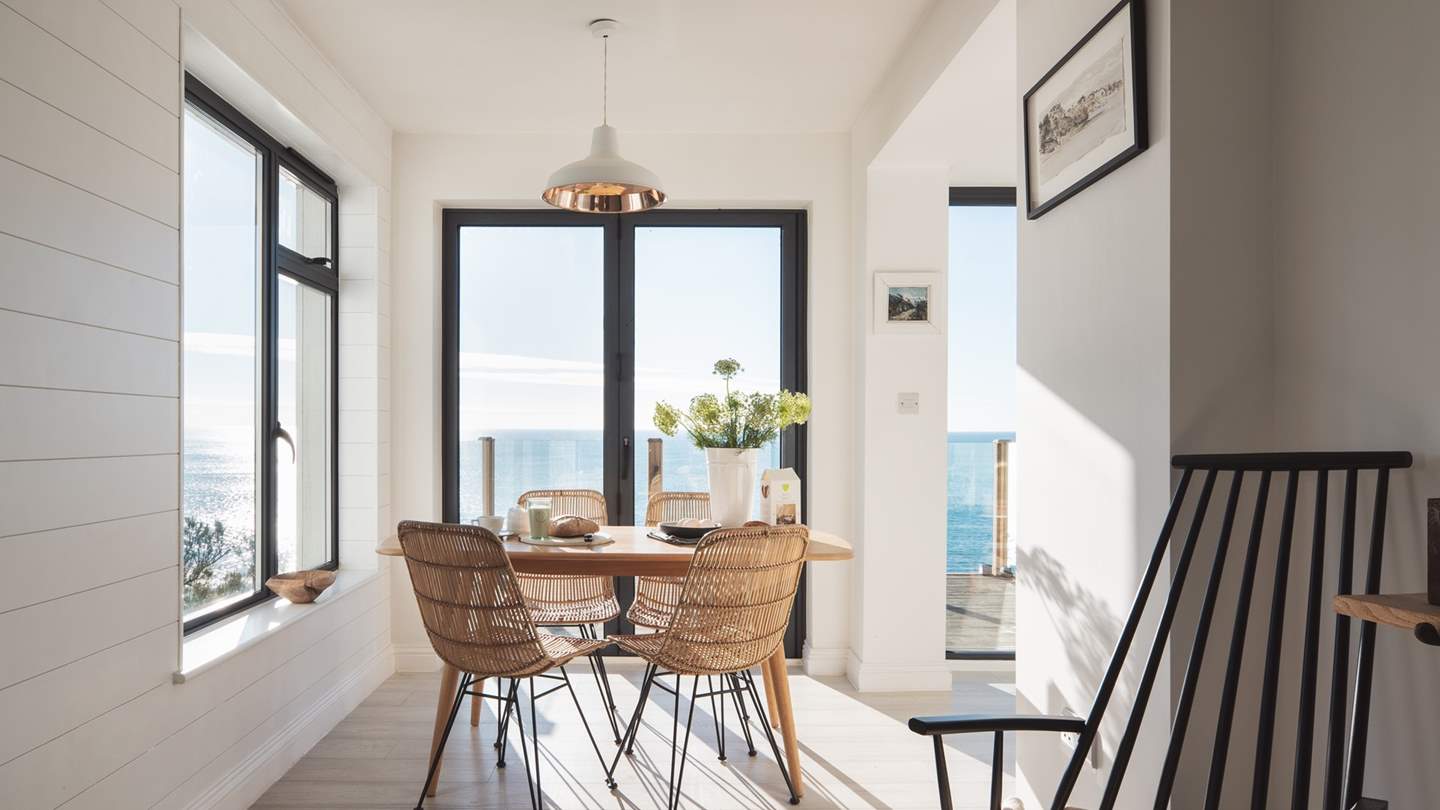 In front of the kitchen is the gorgeous dining area with dual-aspect windows, meaning there's glorious sea views wherever you're sat
