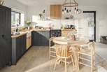 The kitchen and dining area enjoys views from the floor to ceiling glass windows over the moorland, sea and mountains beyond