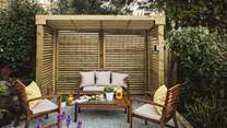 The back garden is home to a sheltered seating area, perfect for those seeking a little privacy