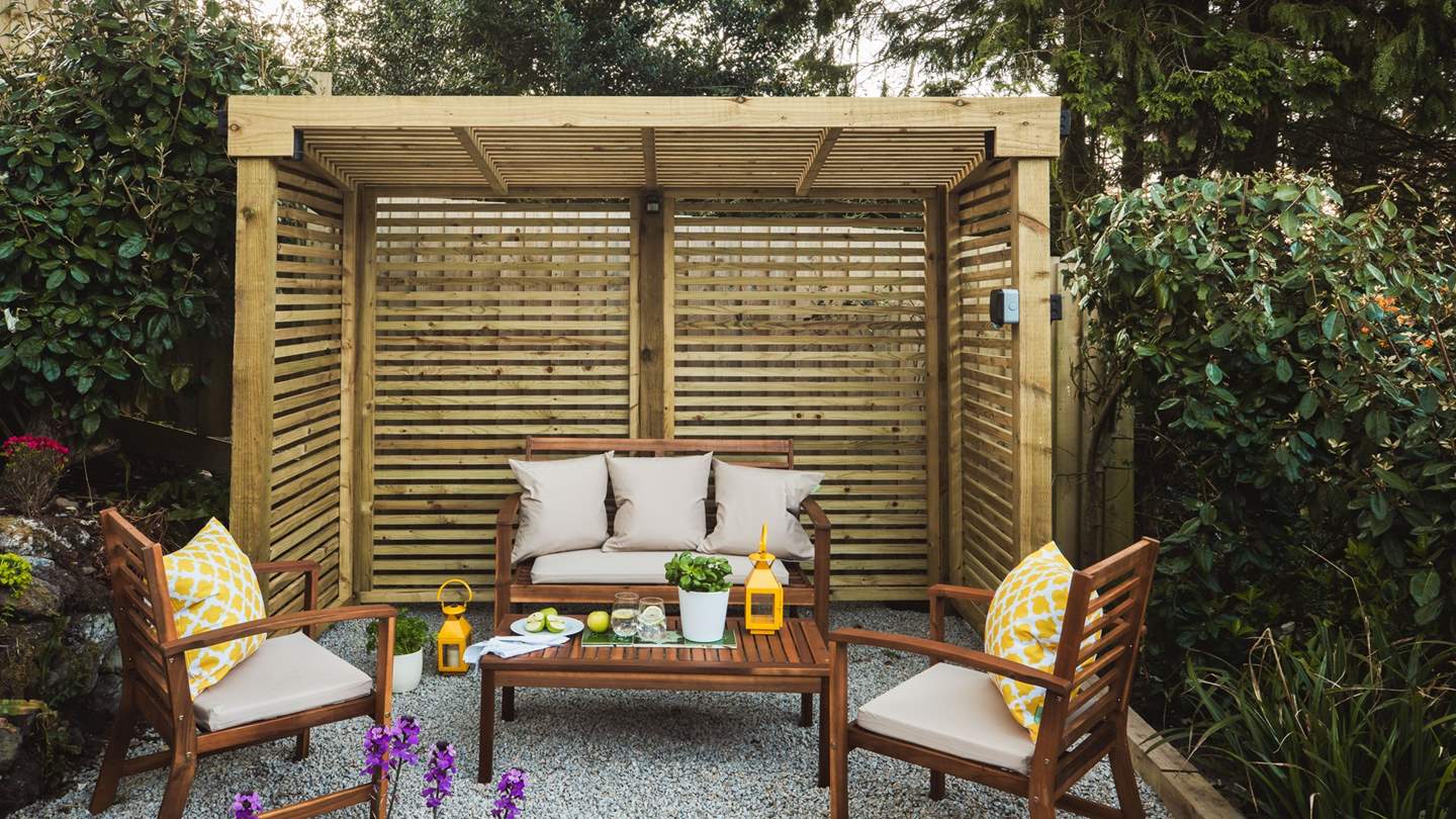 The back garden is home to a sheltered seating area, perfect for those seeking a little privacy