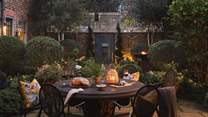 The outdoor table for four is beautifully bordered by manicured hedges - a divine setting after dusk