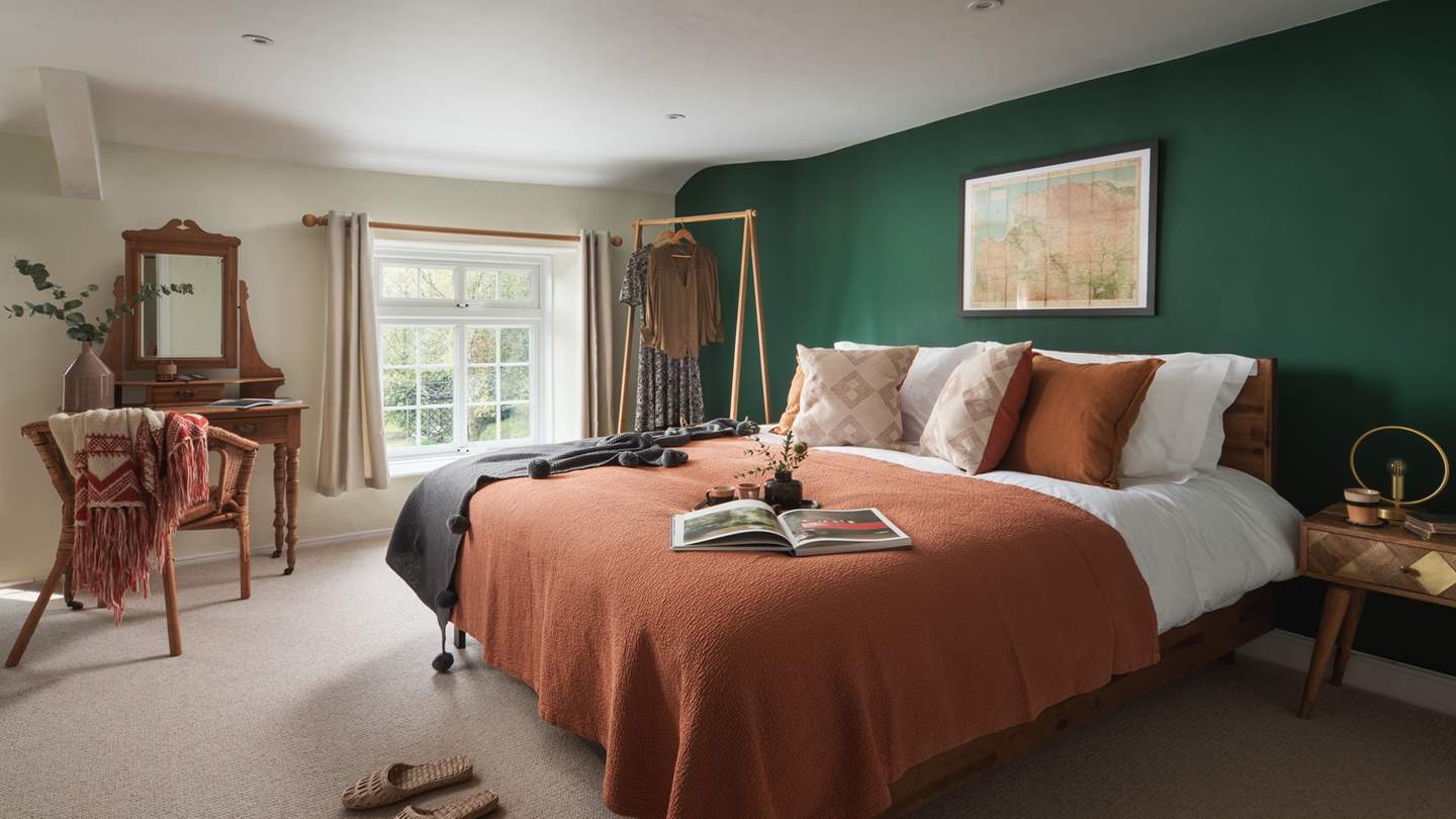 The stunning, earthy master bedroom is just waiting to welcome you