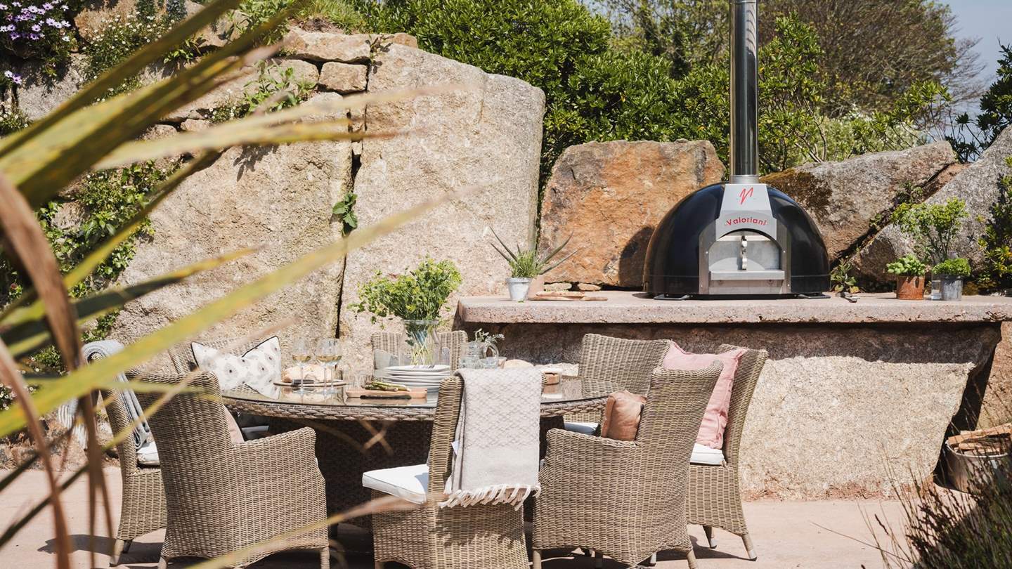 In addition, there's a second terrace area near the pizza oven, with its own full wicker glass top table and wicker dining chairs