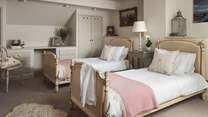 The third bedroom is a delightful twin, complete with French-inspired beds, built in wardrobe, chest of drawers, desk and dressing table