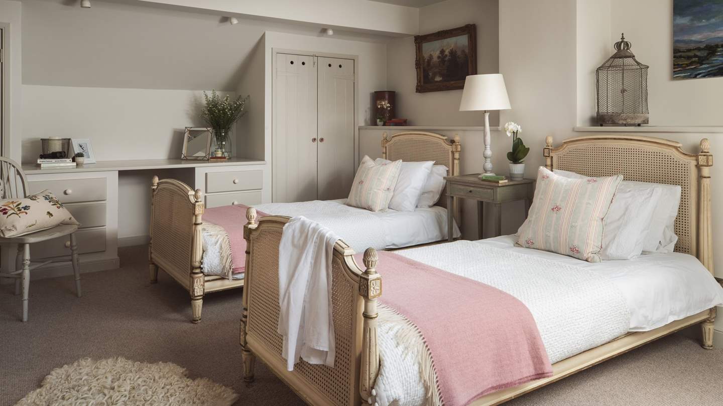 The third bedroom is a delightful twin, complete with French-inspired beds, built in wardrobe, chest of drawers, desk and dressing table