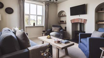 The lovely living room with wood burner is a cosy space made for moments of relaxation 