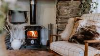 A flickering wood burner offers a warm welcome