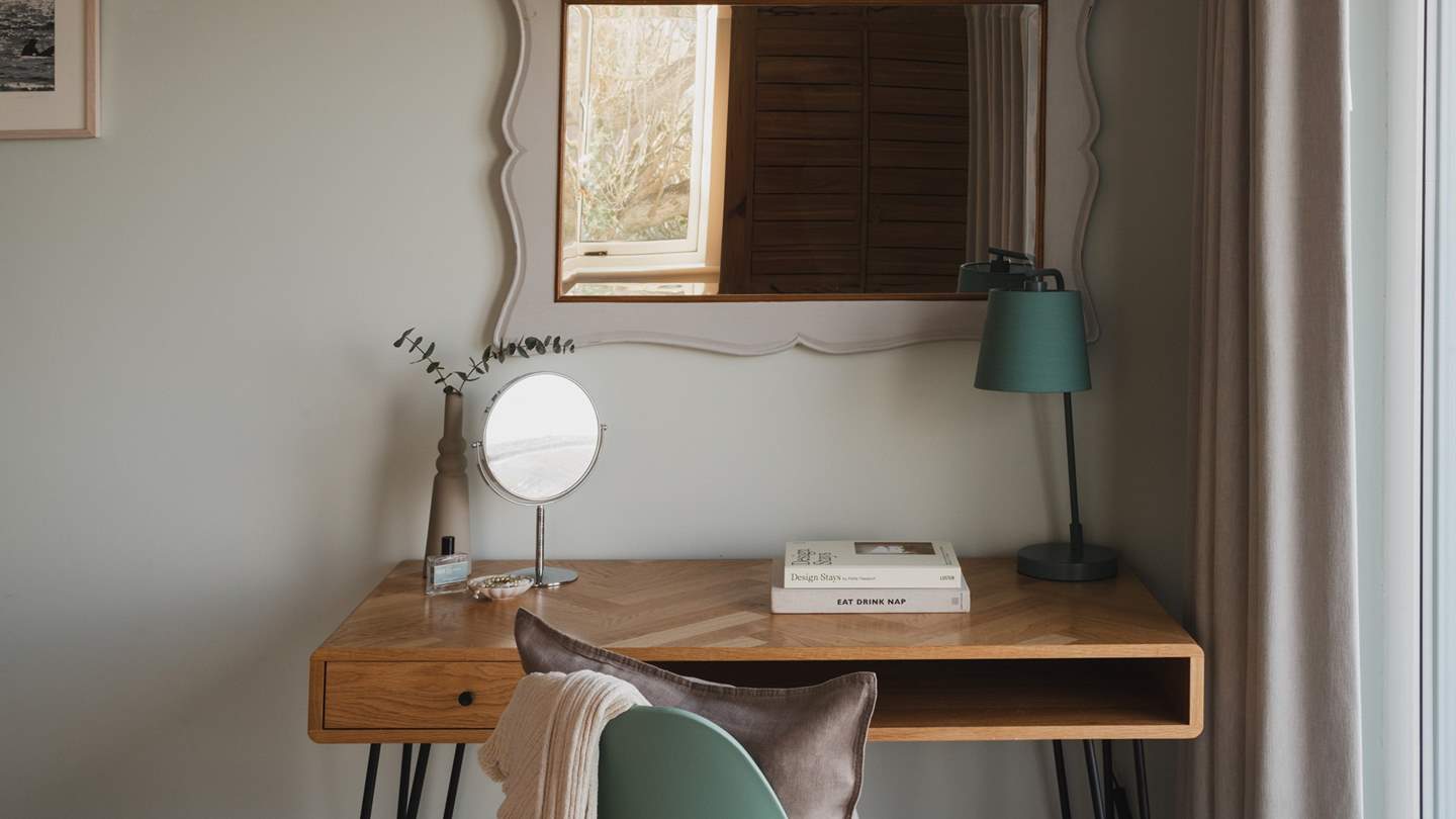 An elegant dressing table sits beside the window