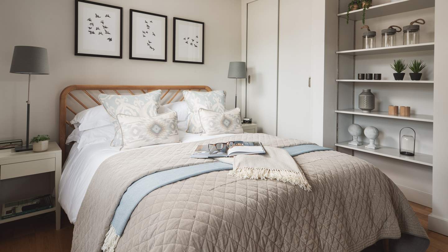 Accompanied by delightful bedside tables with reading lamps, a built-in wardrobe along with a pretty artwork and decorative features...