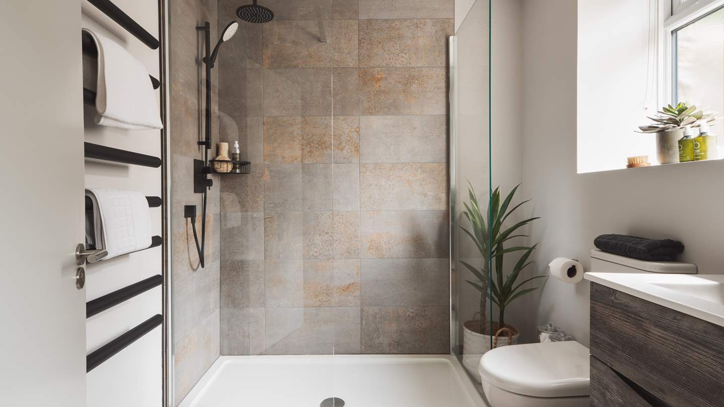 Uncover the family bathroom with a walk-in shower, featuring luxury rosemary and bergamot toiletries from St Kitts Herbery and a heated towel rail.
