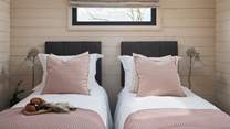 The bed in the pretty-in-pink second bedroom can be set as a super-king or a twin