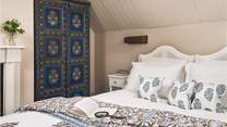 Boasting a vaulted ceiling, and colourful Indian wardrobe adding character to this charming bedroom...