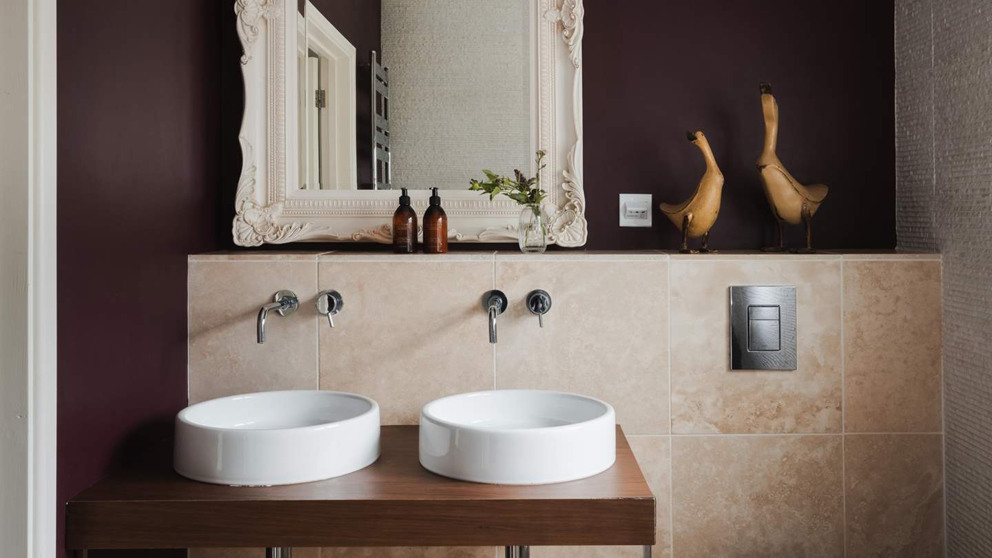 The en-suite has two vanity sinks and a freestanding bath