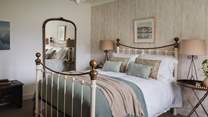 Bedroom two boasts a king size bed dressed in rich linens and beautiful throws