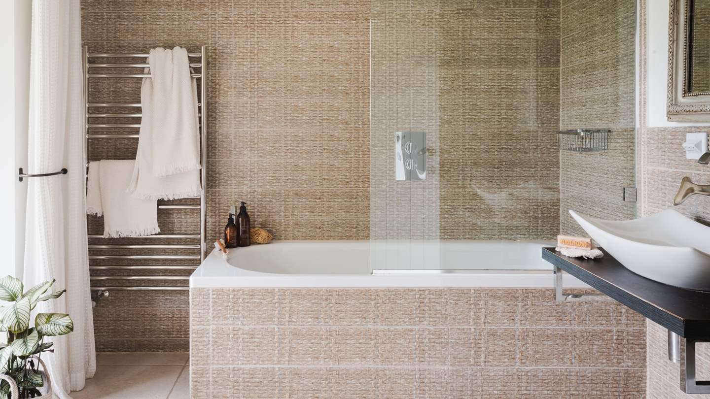 A bath and overhead shower offer rejuvenating soaks, leading onto a darling balcony which offers breath-taking views over the gardens