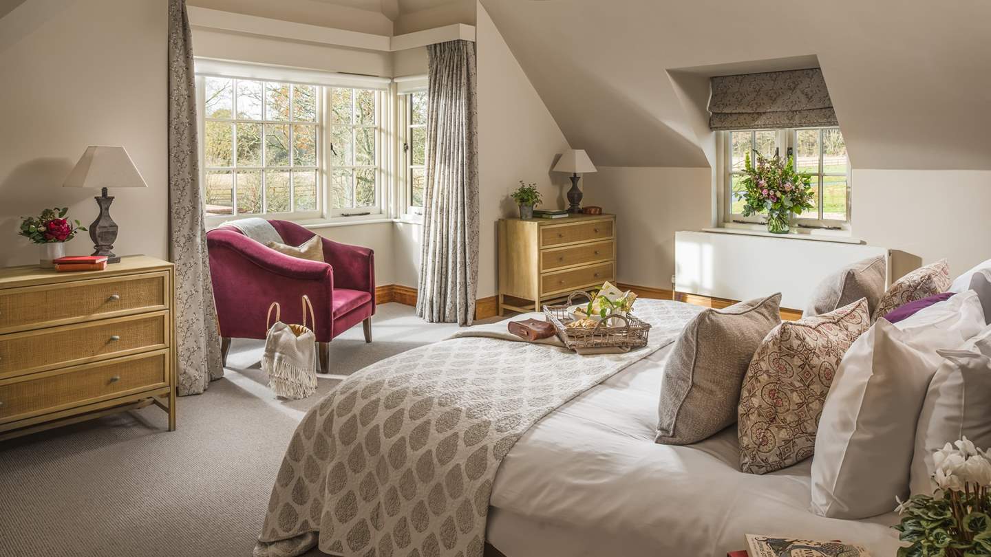 The en suite master bedroom is simply beautiful with a semi-vaulted ceiling, dual-aspect windows and a sumptuous king-sized bed