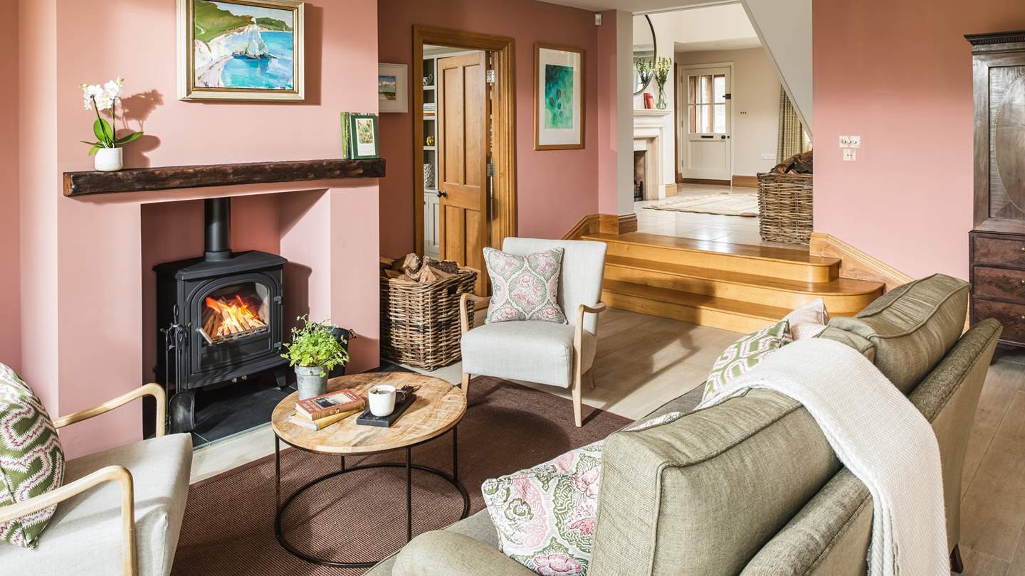 Steps lead down to the open-plan kitchen complete with a charming sitting area with wood burner 