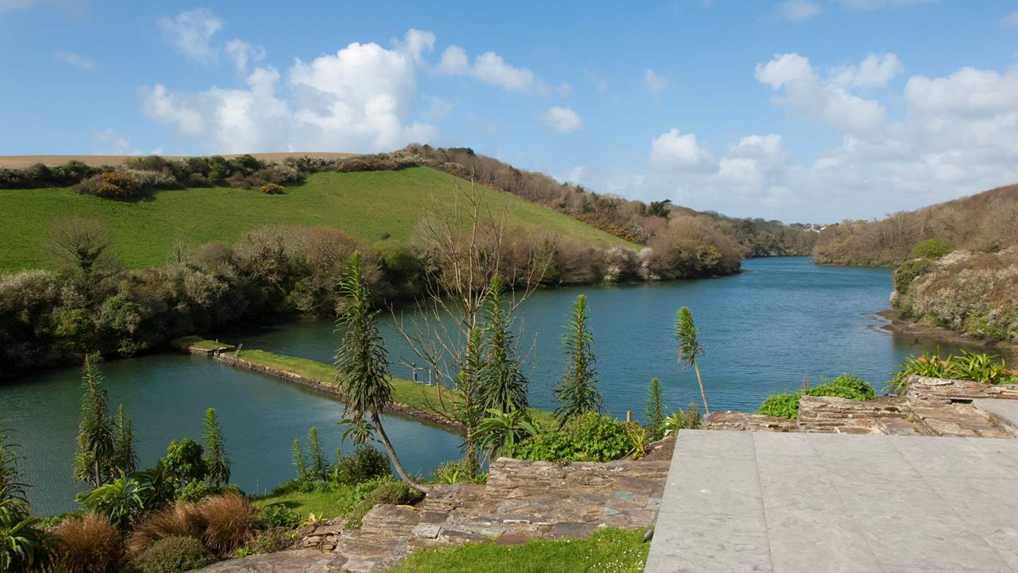 With lawns below leading down to planted borders and the water's edge