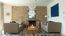 Both sitting rooms have wood burners or open fires. The walls are adorned with modern art