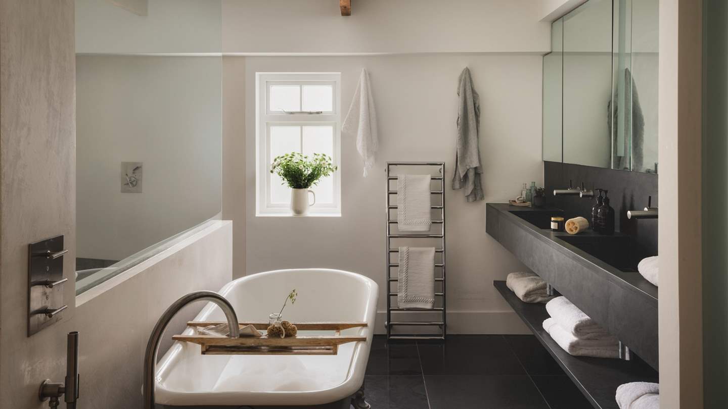 The en suite features a freestanding rolltop bath and a walk-in shower, offering a sanctuary for peaceful pampering