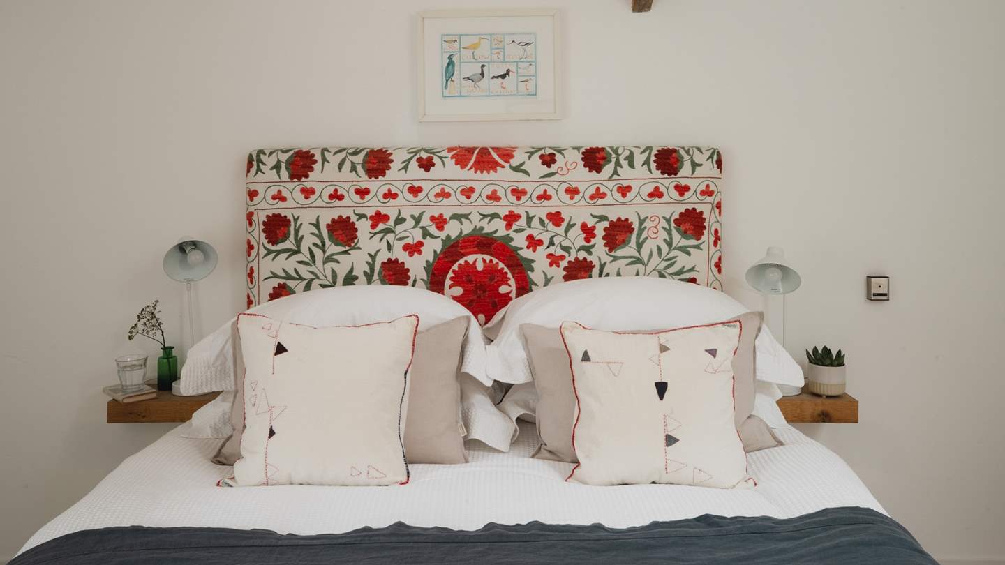 A cosy nook on both sides of the bed, where reading lamps invite evenings spent with your favourite page-turner