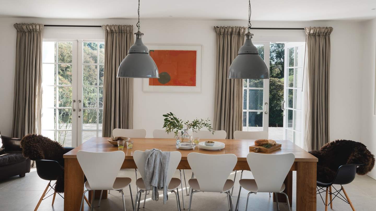 Pendant lights reclaimed from the Rover car factory hang over the oak Conran refectory table and Eames chairs