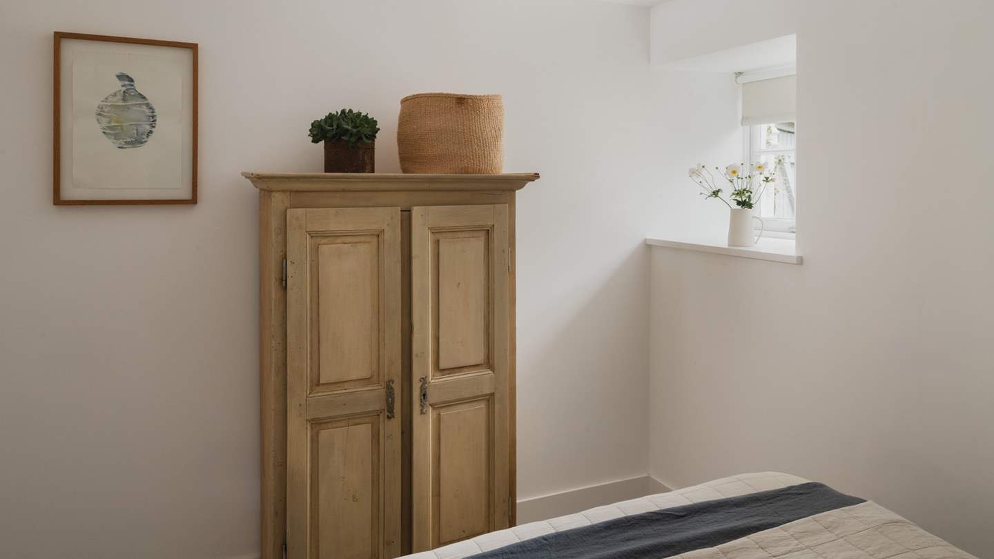 A charming pine wardrobe provides plenty of space for your staycation belongings 